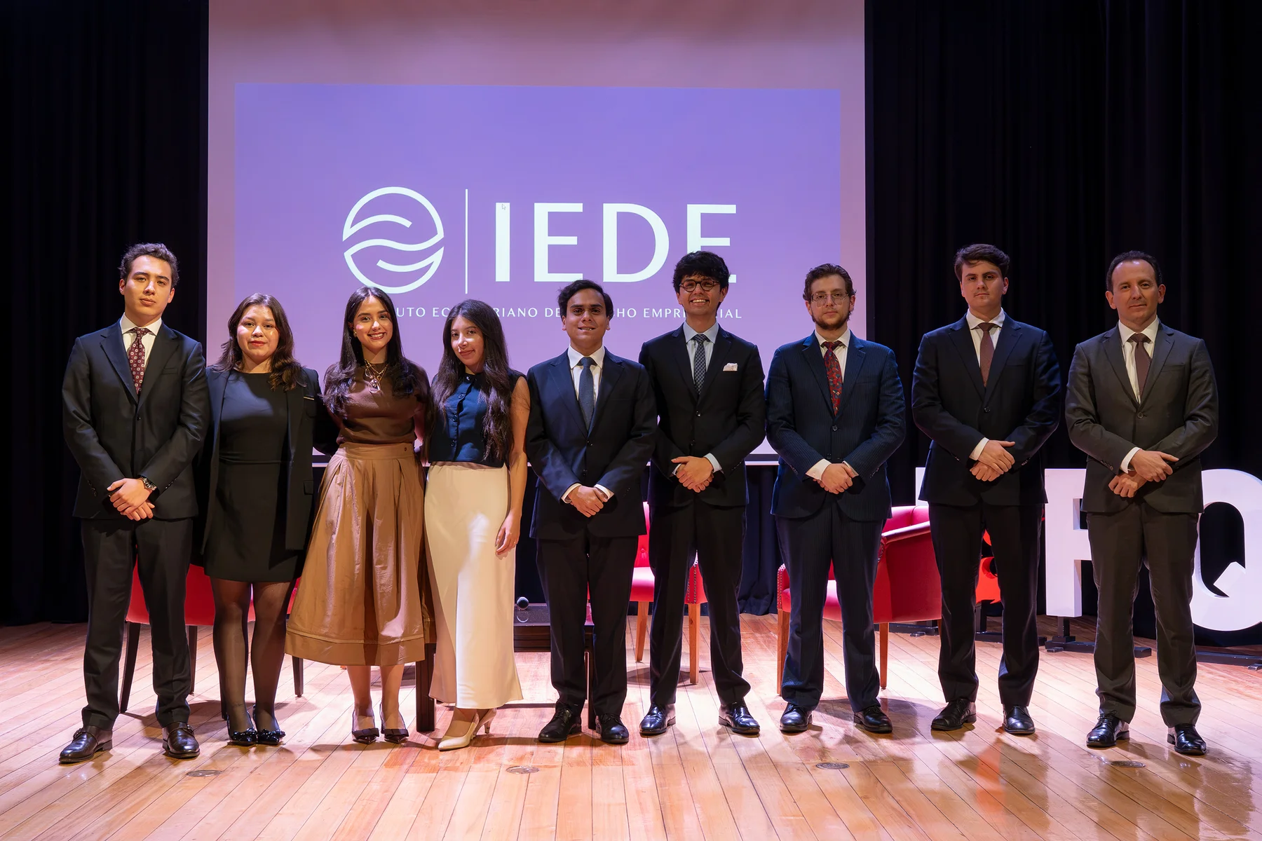 Fotografía grupal en el escenario del evento inaugural del IEDE